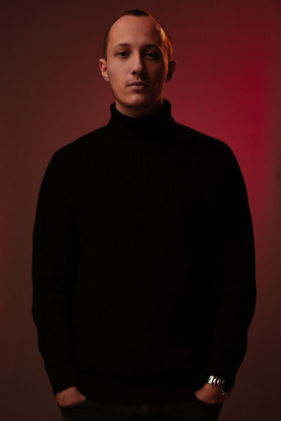 Melvyn Vogelsang qui pose en tant que model, en studio photo à Colombier, à neuchâtel en suisse. Fond rouge et habit noir. Editorial de mode